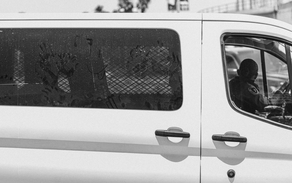 Handprints on the window of a federal detention van as it pulls out of Metropolitan Detention Center during a protest in Los Angeles, CA on the 4th of July 2025