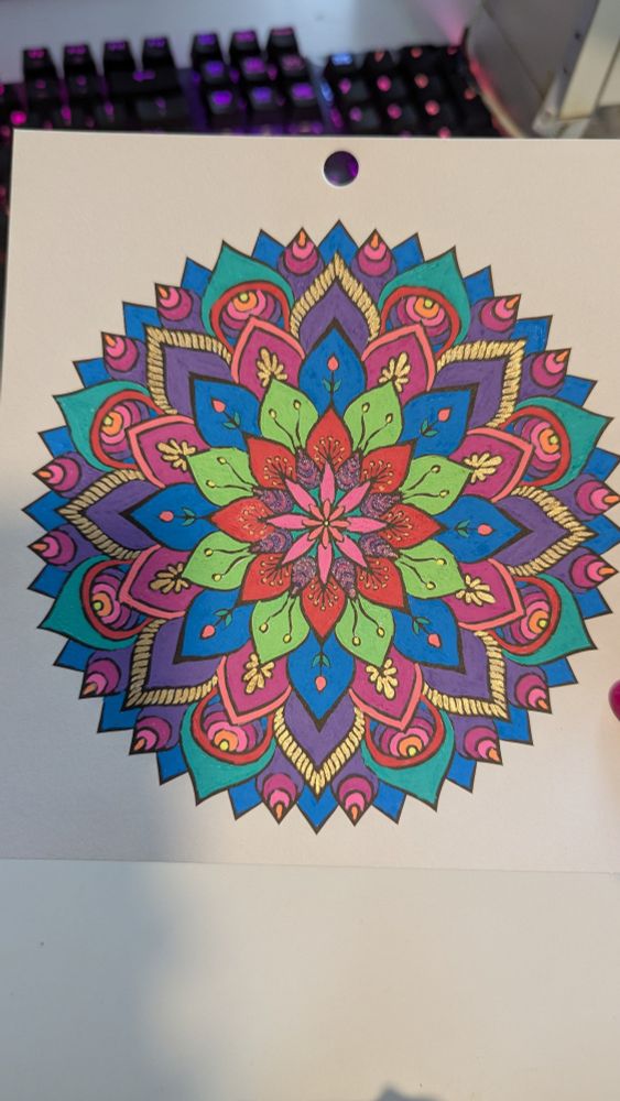 A colored mandala featuring colors like blue, green, red, purple, and pink as well as a hint of gold, orange, and yellow.