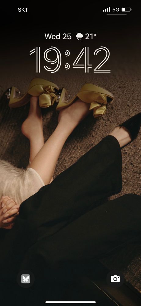 screenshot of a phone lock screen with irene and seulgi’s legs wearing heels and hands clasped together. 