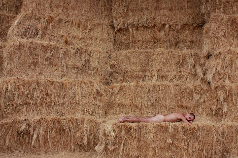 Tumbado bocabajo sobre balas de heno apiladas. Fotografía de David Semuret.