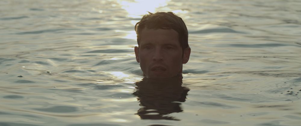 Fotograma de «L'Inconnu du lac» (Alain Guiraudie, 2013). En el centro, la cabeza de Franck, interpretado por Pierre Deladonchamps, sobresale del agua mientras nada.