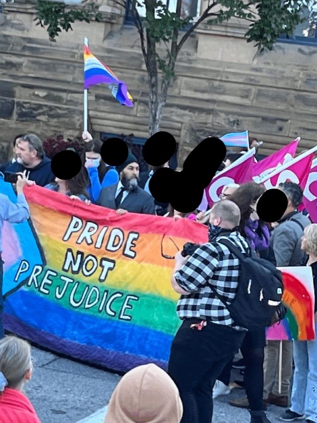 NDP leader Jagmeet Singh marching with counter-protesters on September 20th, 2023, and holding a rainbow flag banner that says, "Pride, not prejudice."