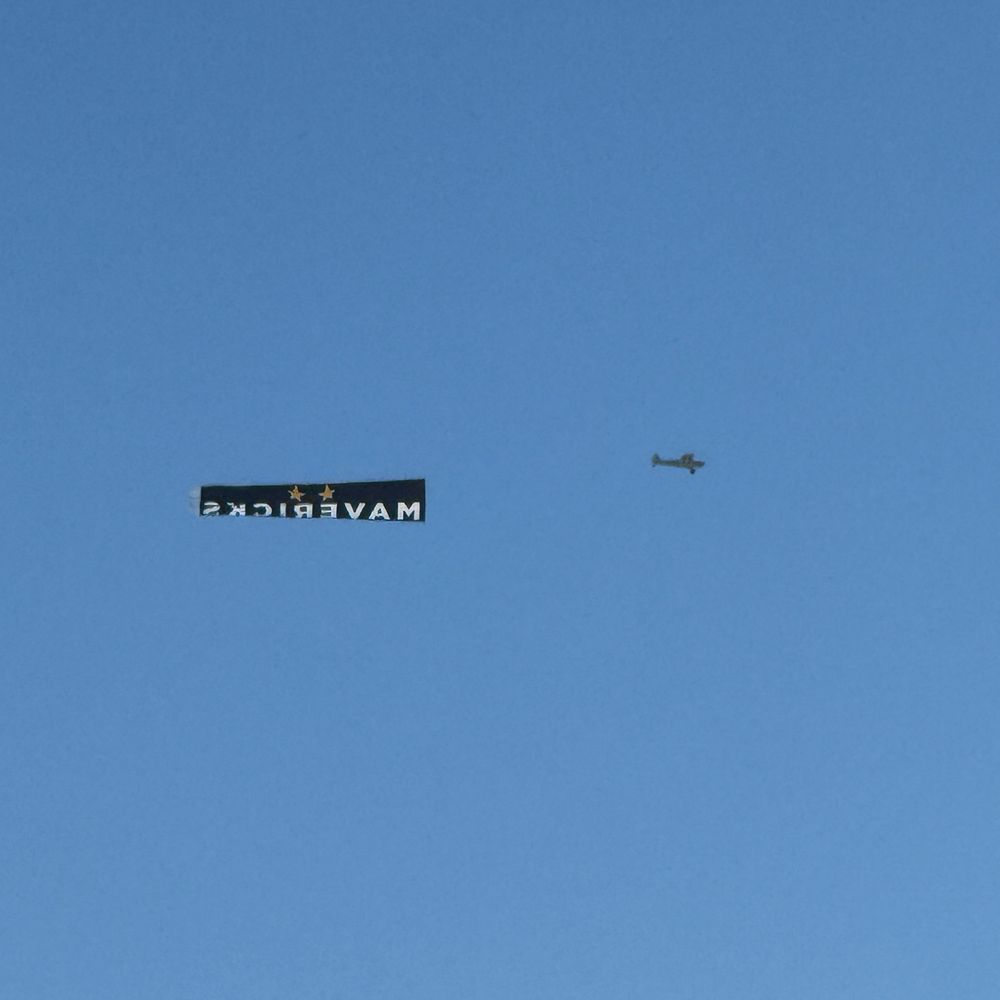 a photo of an aircraft towing a sign for mavericks revue bar in cape town, south africa