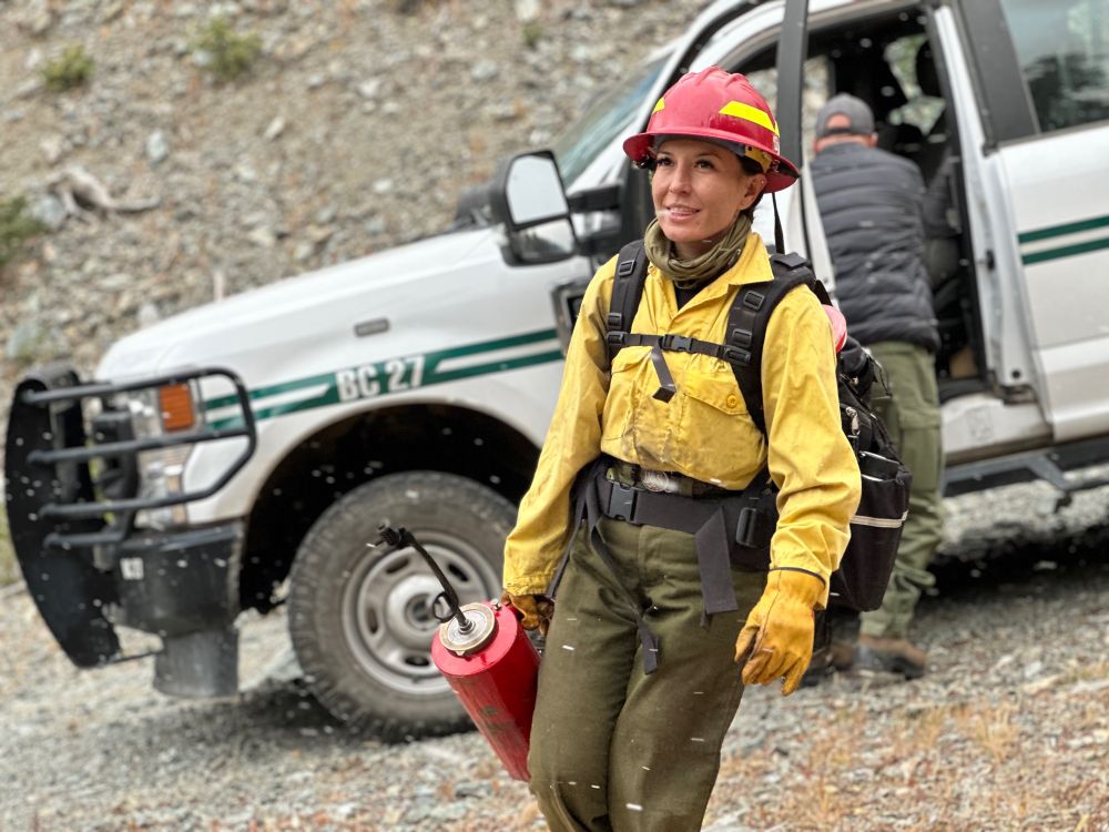 Fire crew member walks with a drip torch