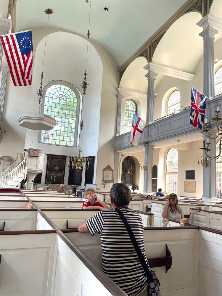 Visitors in the unique box pews of the Old North Church. Many are listening to audio guides. 