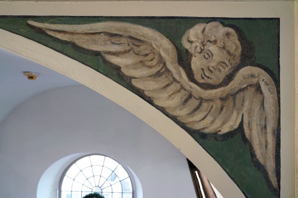 A close-up photo of one of the angels painted in Old North Church's balcony arches.