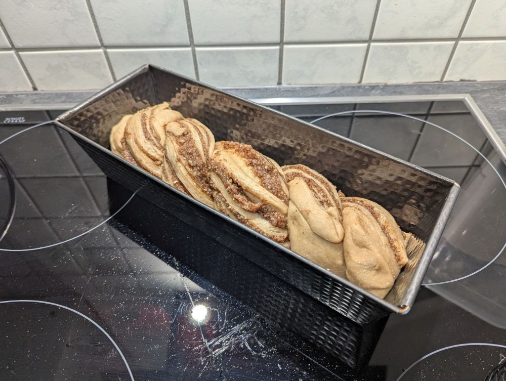 Ein Nusszopf nur mit Mandeln statt Nüssen in einer Kastenbackform vor dem Backen.