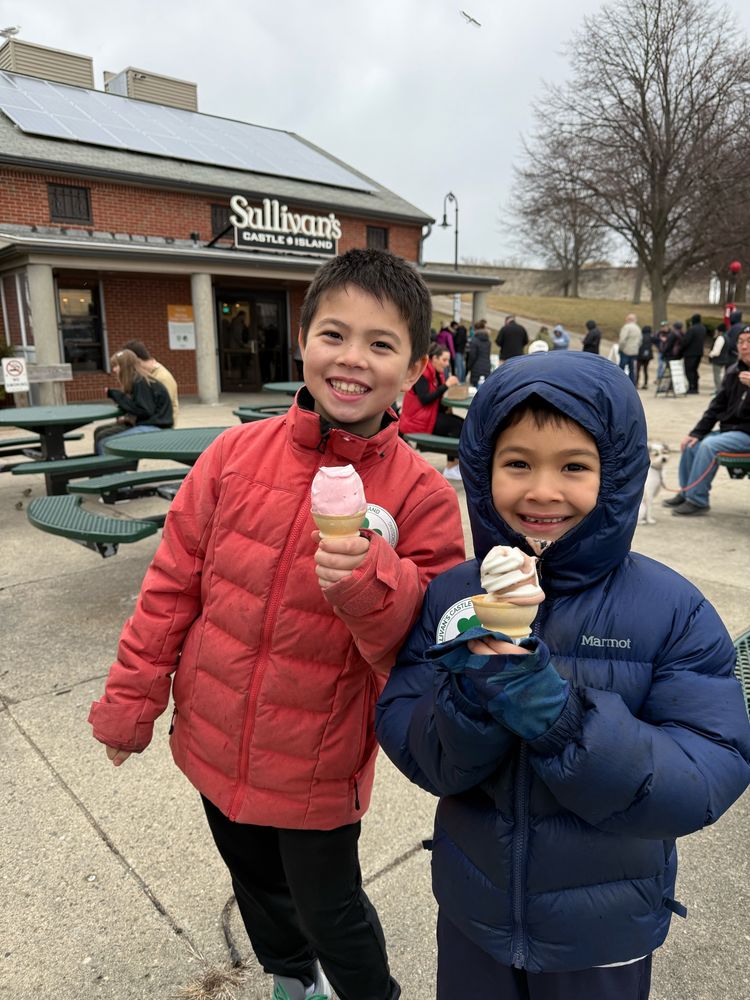 Blaise & Cass are bundled up in winter coats holding their soft serve cones outside Boston’s very own James Beard award-winning classic: Sullivan’s Castle Island