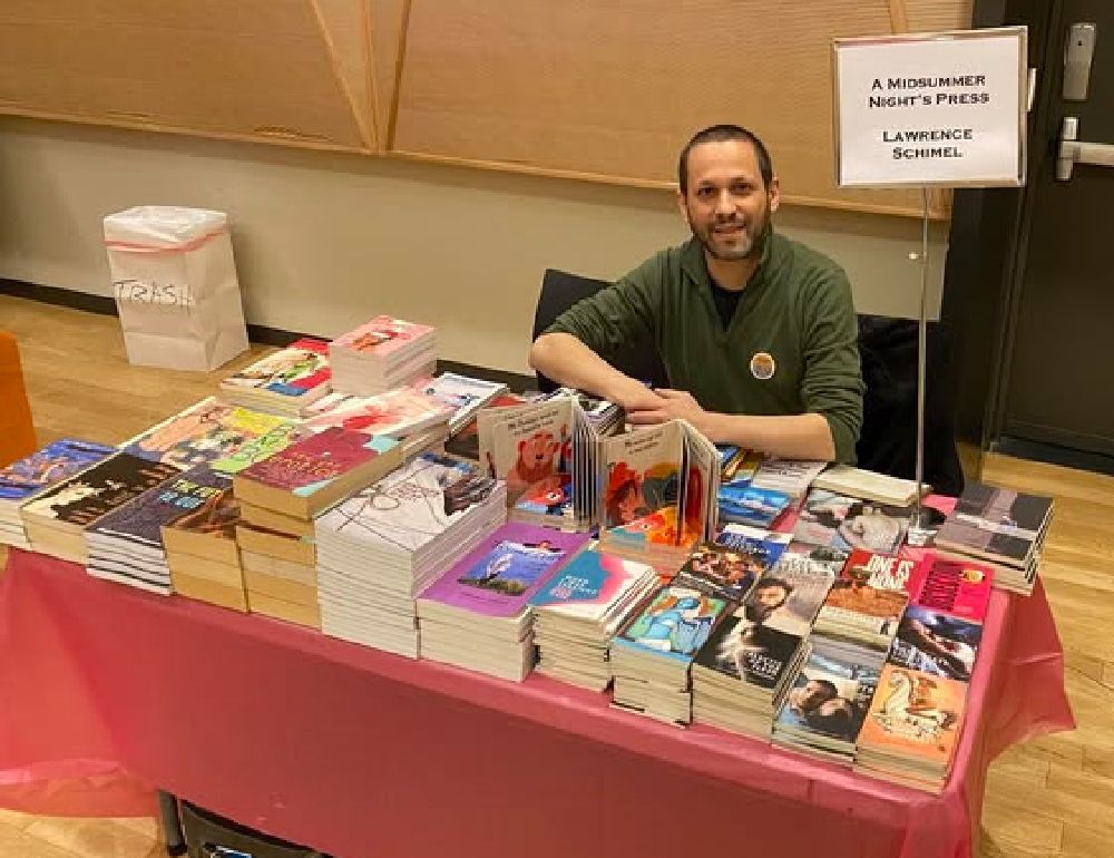 Lawrence Schimel, author, translator, all round easy on the eyes, sat opposite the ReQueered Tales booth. He's every bit as lovely as his smile here.