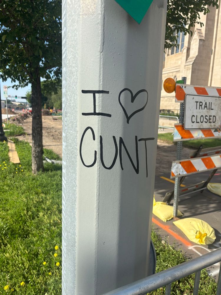 Sign post tagged to say “I heart cunt”