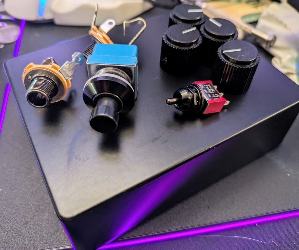 Parts for building my blackout Rat pedal: 1590BB2 enclosure in black powdercoat, small toggle switch in black, 1/4 jacks in black nickel, footswitch with black metal, black dress nuts, and black Rat style knobs.