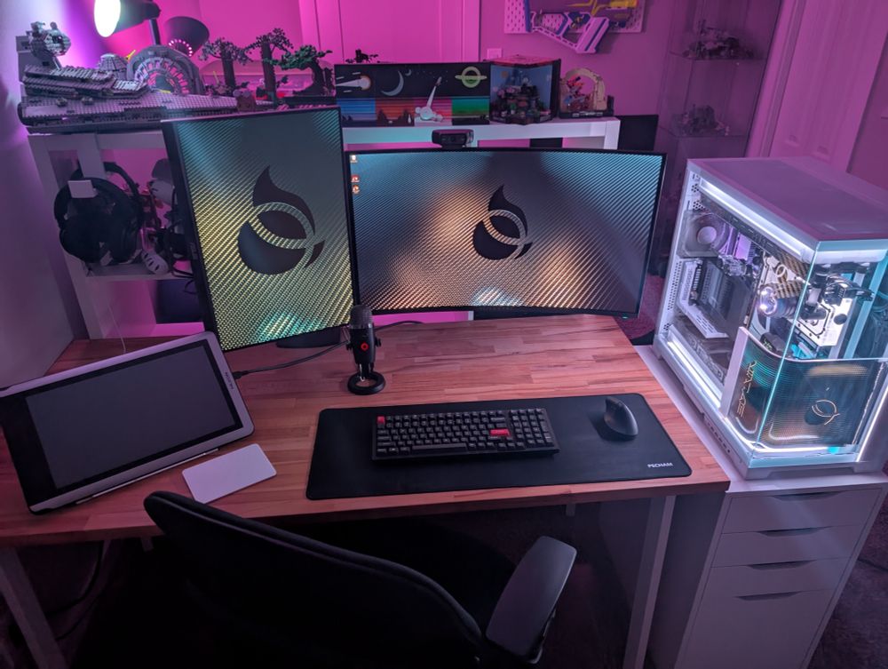 A gaming PC set up with dual monitors and drawing tablet in a room with Legos on display
