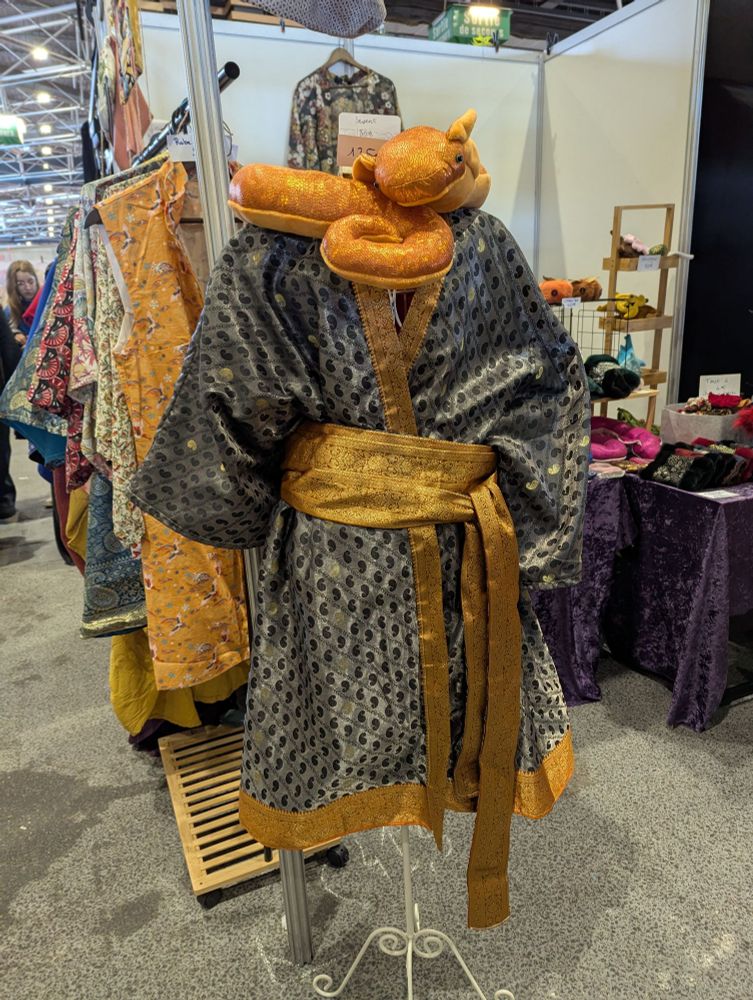 Kimono en tissu indien satiné surplombé d'un serpent en peluche sur un mannequin