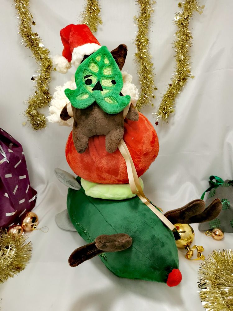 Korogu de Noël en peluche sur une hotte de Noël trop grosse pour lui sur un propulseur avec des bois de rennes et un nez rouge