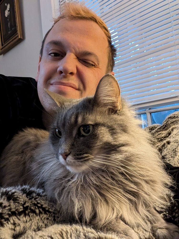 Phil behind his long haired cat river-she is dark grey with long hair