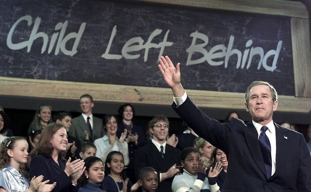 President Bush in front of a sign that reads "child left behind"