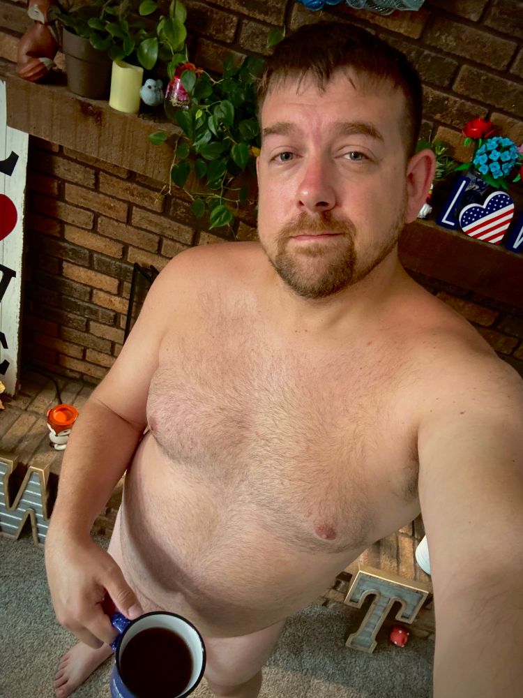 Nudist standing with a cup of tea