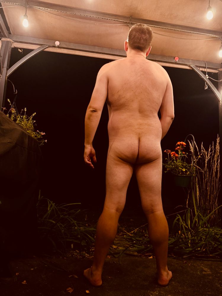 Standing naked on the back patio