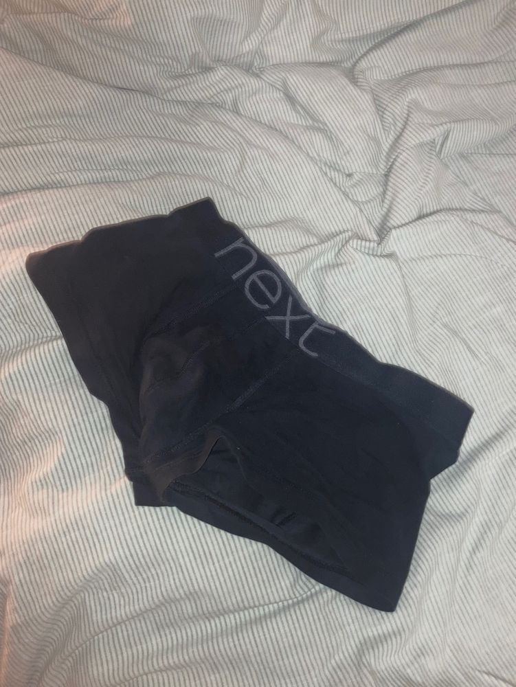 A pair of black, sweaty trunks with just a hint of pre, the cup still holding the shape of the dick that was in it
