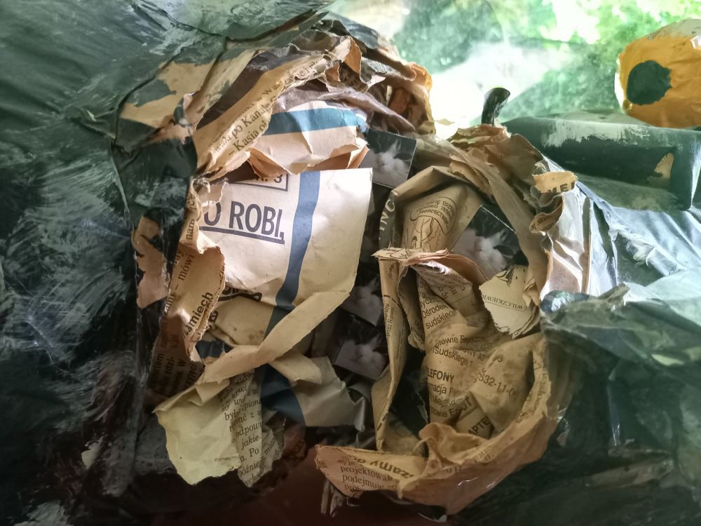 closeup of the crack revealing tiny paper cube wawa cats stuffed between the newspapers