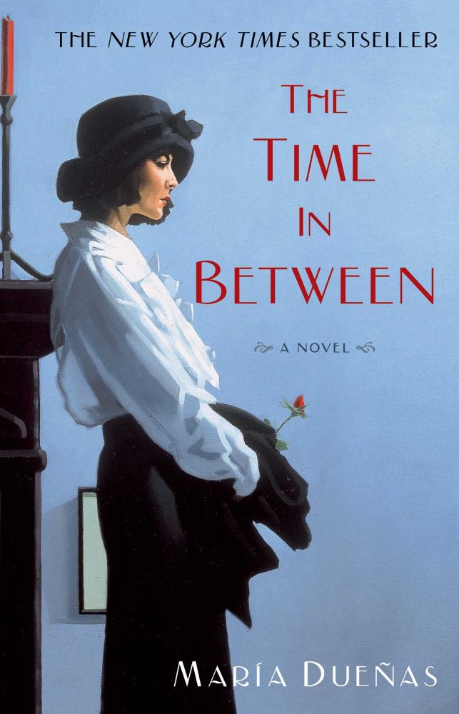 Image shows the front cover of María Dueñas’ novel The Time In Between - a young woman in a 1930s style black skirt, white blouse, and cloche-ish hat 