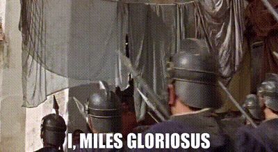 Gif shows a scene from the film A Funny Thing Happened on the Way to the Forum, in which Ancient Roman soldiers are marching through the streets of Ancient Rome singing about their commander Miles Gloriosus