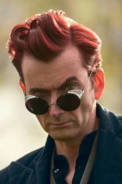 A redheaded man in sunglasses - the actor David Tennant - stares at the camera.