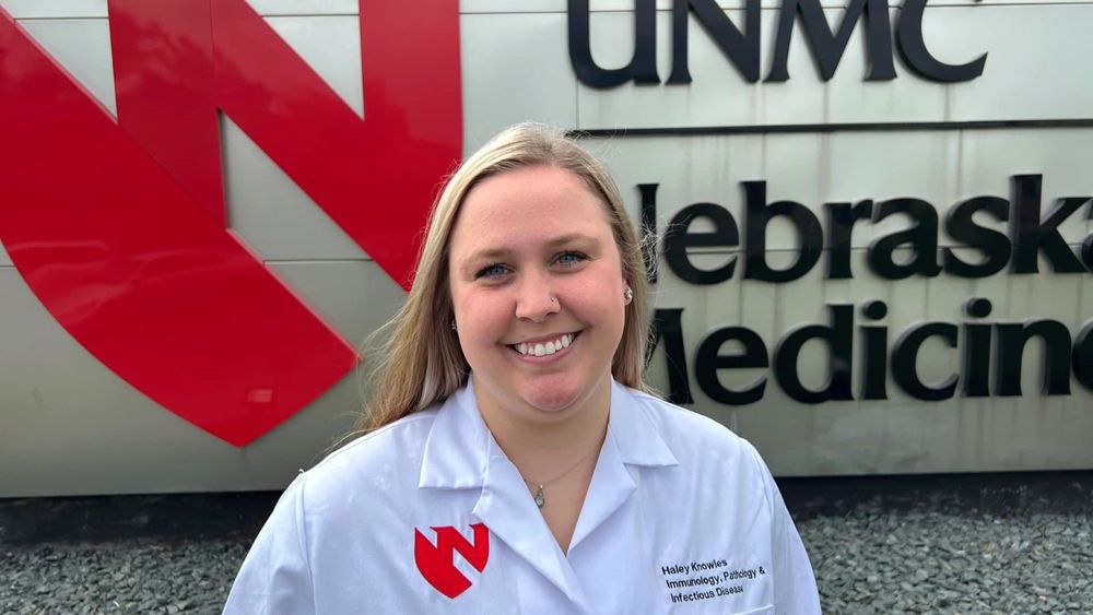 Haley Knowles, a PhD student in the IPID program hosted by UNMC's Department of Pathology, Microbiology & Immunology, in front of UNMC/Nebraska sign