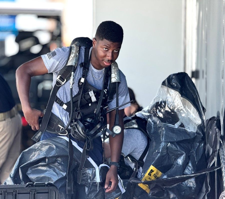 National Guardsman putting on protective suit during drill on UNMC campus