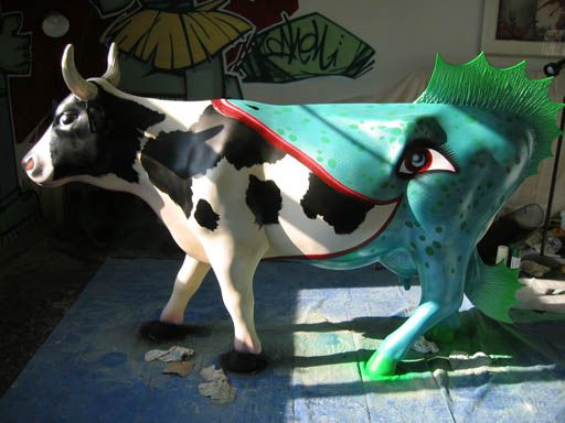 Cow painted to look like it has been half-eaten by a green alien