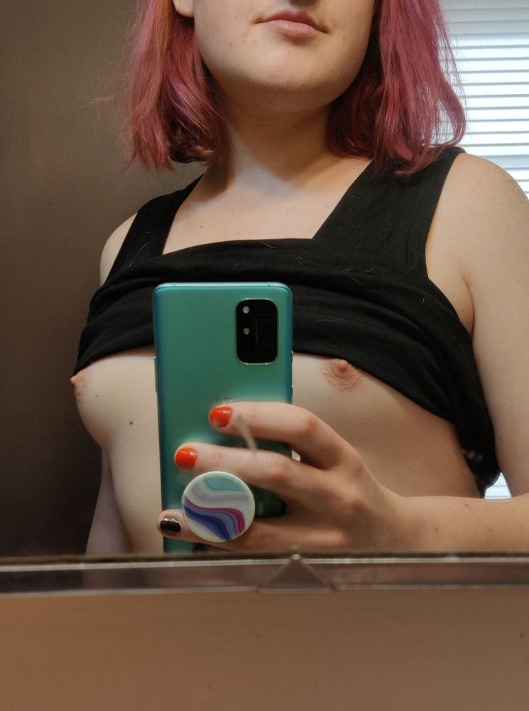 A mirror selfie of me with my tight tank top pulled up just above my nipples