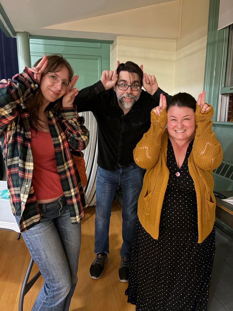 Two girls making mock horns on the side of author Joe Hill 