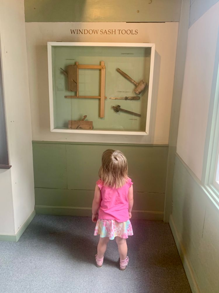 A child looking up at a display of window sash tools