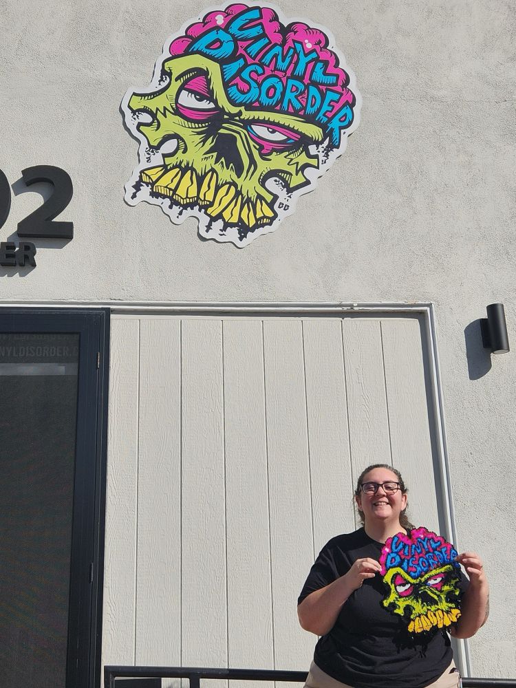Cen outside of Vinyl Disorders shop in Dana Point, CA with the perler she made of their logo!