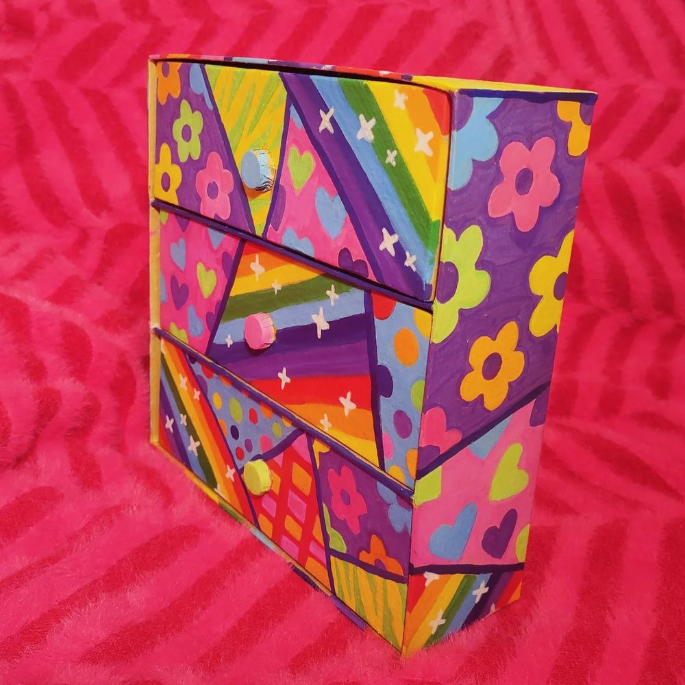 Small three drawer unit painted in a variety of rainbow patterns