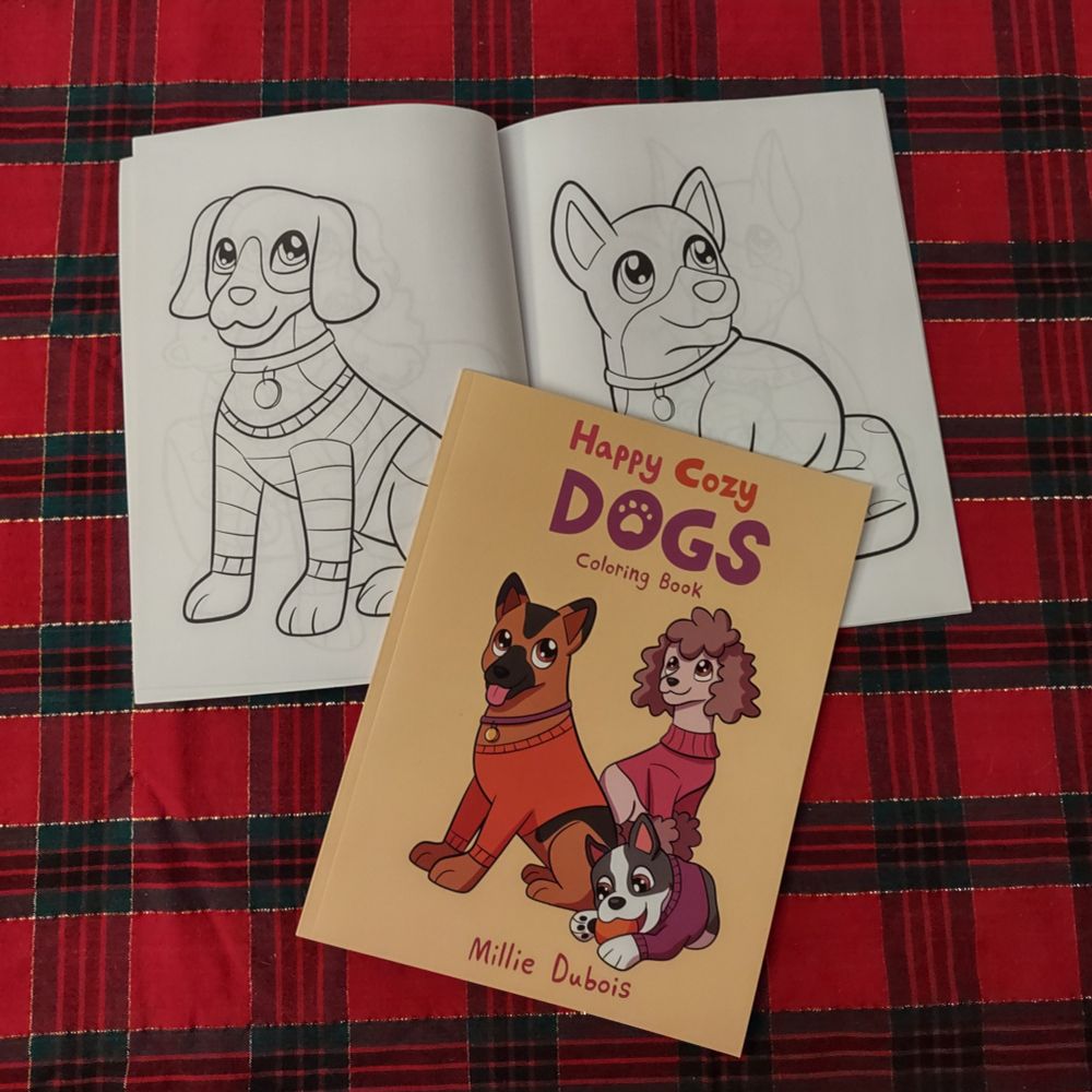 Happy Cozy Dogs coloring book opened to a two page spread of a beagle and a corgi