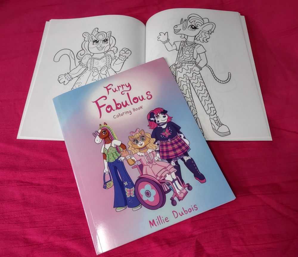 Photo of 'Furry Fabulous coloring book' cover next two a two page spread showing a cat in a frilly dress and a mouse in patterned overalls. The cover depicts a horse girl with twists and a 2000s style outfit, a cat in a wheelchair in a frilly dress and a dalmatian in a goth/punk style outfit 