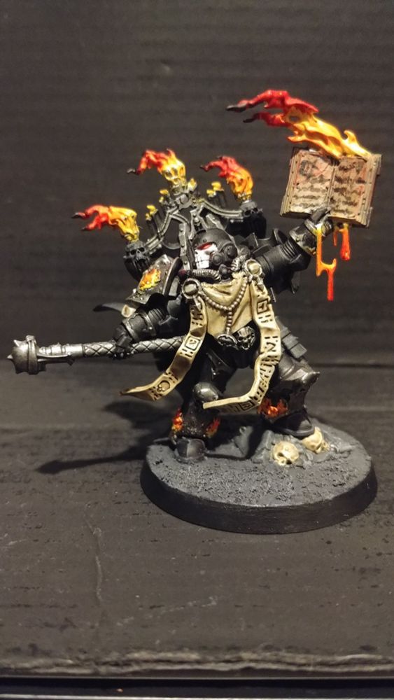 Silent Sermon stands with his book raised and wreathed in flames. His Rod pointed outwards at his foes.