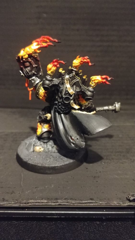 Silent Sermon back view, showing his flowing cape and backpack wreathed in flames.