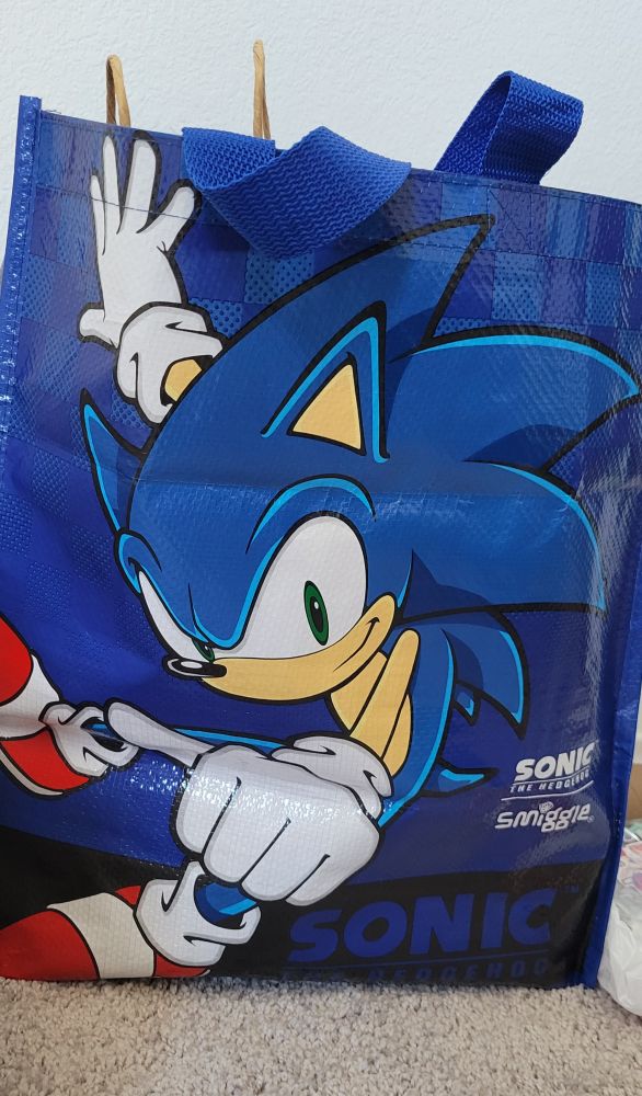 The front of the Smiggie Sonic tote bag, featuring Sonic himself with a blue checkerboard background and his name emblazoned on the bottom.