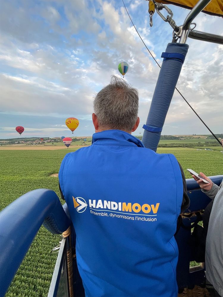 Le directeur de PYRAMIDE EST, avec son gilet Handi Moov qui contemple le paysage alors que la nacelle décolle.