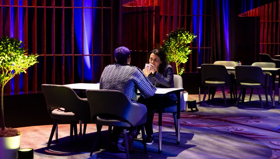 Two people having a meeting across a desk.