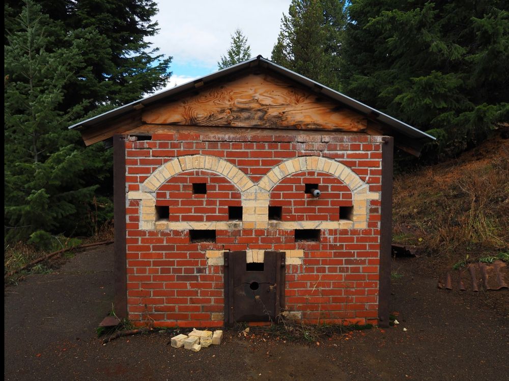 A small, red brick building with yellow bricks in rounded window patterns