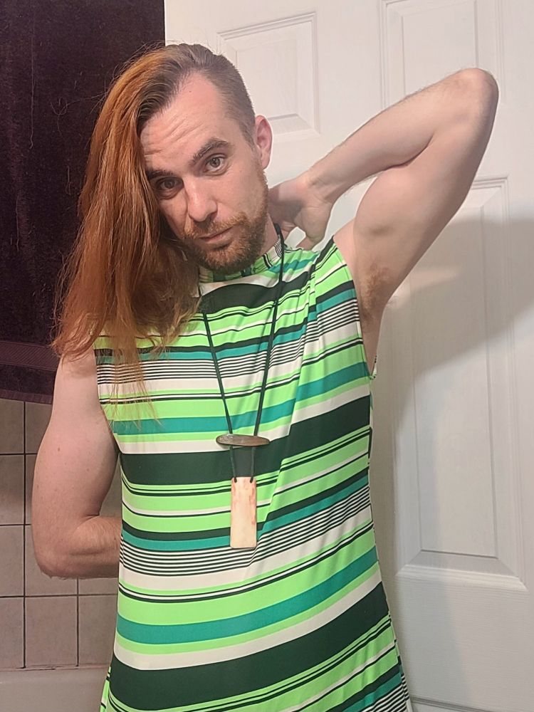 A person wearing a striped green and black tanktop and shirt