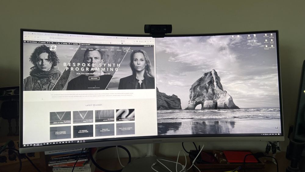 Photo of my studio monitor showing my website and the Windows background image resplendent in shades of grey!