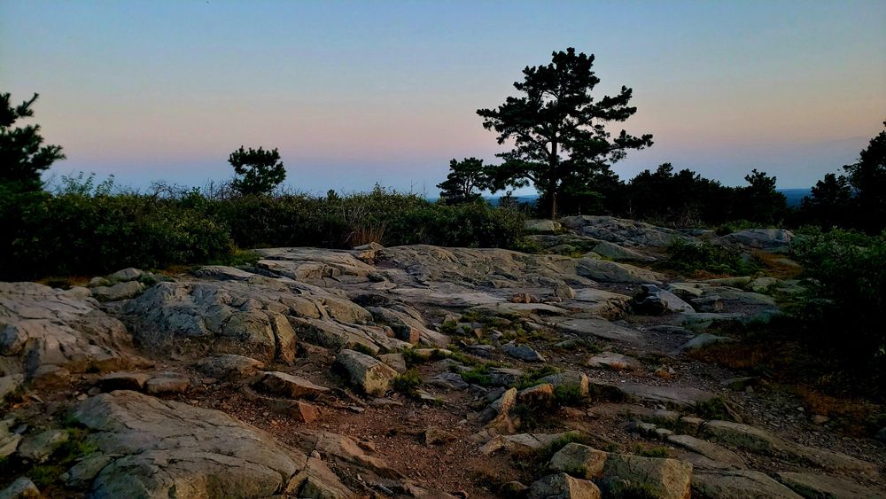 The rocky summit of Buck Hill catches the first light of the day.