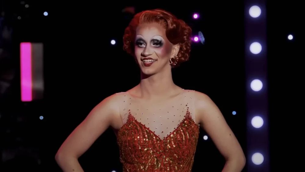 imagem mostrando a drag queen susie toot, uma drag que usa maquiagem um pouco exagerada e cabelo vermelho