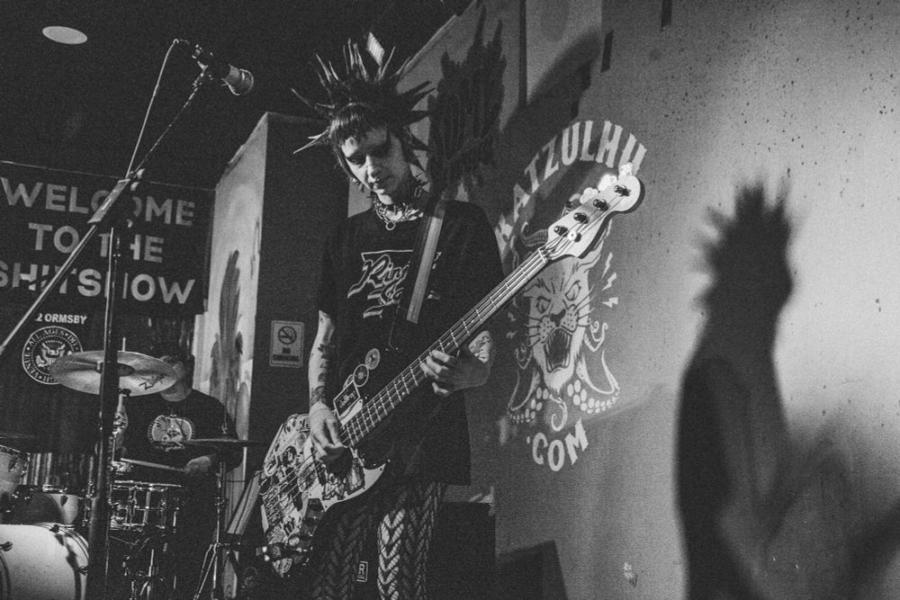 Nowhere Wolves performing: Sara Husser playing drums and Candrika Rice playing electric bass.