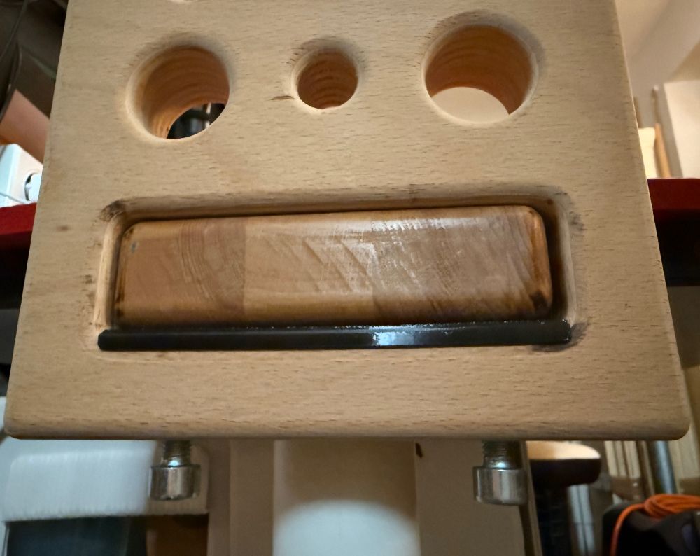 Befestigung der Seitenteile am Tisch durch Klemmung übwer zwei Schrauben. der Schwarze Strich ist eine Druckplatte zwischen Schrauben und Tisch-Holz, die ich dafür gedruckt habe