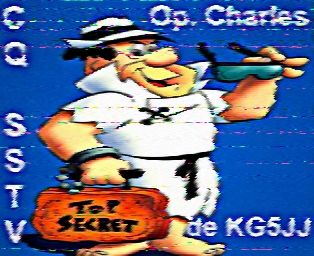 SSTV call sign image featuring Fred Flintstone dressed as a Private Eye carrying a stone briefcase with "top secret" written on it and holding a pair of sunglasses in the other hand